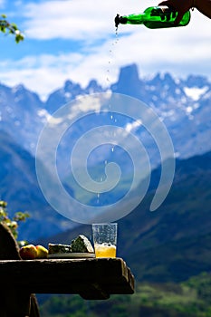 Pouring from high height of natural Asturian cider made fromÂ fermented apples, Asturian cabrales cow blue cheese with view on